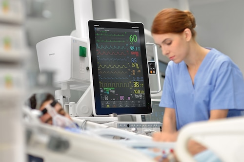 fatigued nurse with patient monitor